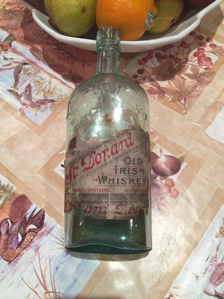 An original bottle of St. Donard's Old Irish Whiskey by Mooney Brothers of Castlewellan, its paper label still legible after more than a century.